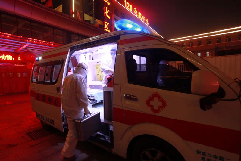 Medical worker in protective suit gets onto an ambulance at a hospital, following an outbreak of the novel coronavirus in the country, in Zhangjiakou