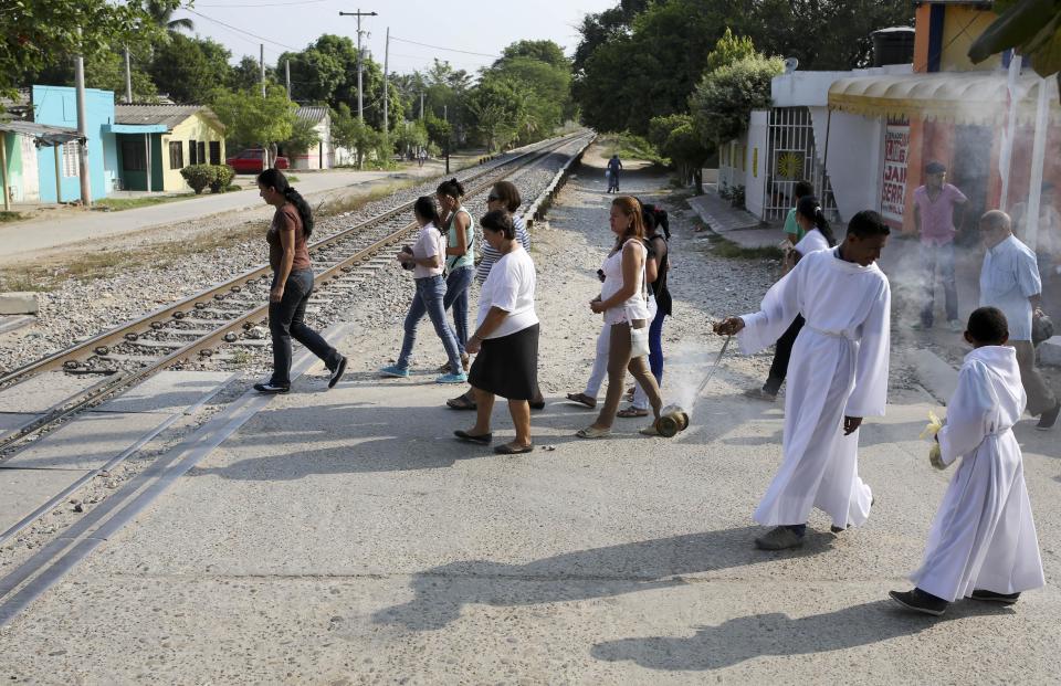 Faithful cross a railroad during Good Friday celebrations in Aracataca, the hometown of late Nobel laureate Gabriel Garcia Marquez in Colombia's Caribbean coast, Friday, April 18, 2014. (AP Photo/Ricardo Mazalan)