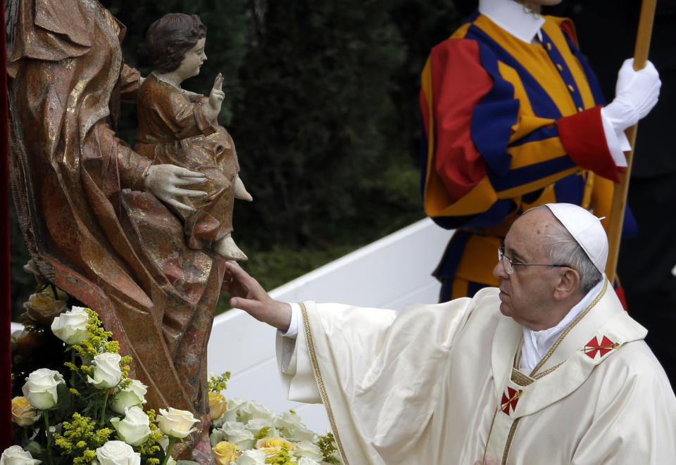 Pope Francis touches a statue of the Virgin Mary as he leads a solemn ceremony in St. Peter's Square at the Vatican, Sunday, April 27, 2014. Pope Francis has declared his two predecessors John XXIII and John Paul II saints in an unprecedented canonization ceremony made even more historic by the presence of retired Pope Benedict XVI. (AP Photo/Gregorio Borgia)