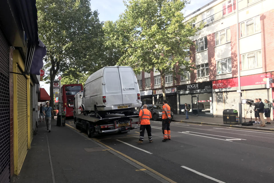 A van, believed to have been driven by the attacker, is loaded at the scene in Leyton, east London, where a police officer was stabbed shortly before midnight after attempting to stop the vehicle.