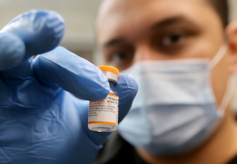 LYNWOOD, CALIF. - MAR. 16, 2022. Nurse Luis Garcia holds a vial of the Pfizer vaccine as he mixes up childrens doses to be used for kids at Hellen Keller Elementary School in Lynwood on Wednesday, Mar. 16, 2022. (Luis Sinco / Los Angeles Times)