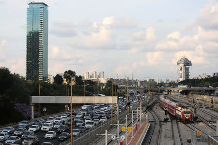 Cars drive on a highway as a train enters a station in Tel Aviv, Israel November 25, 2018. Picture taken November 25, 2018. REUTERS/Corinna Kern