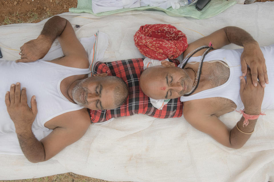 Shatrugan Sharma and Sravankumar Gujjar, from the state of Rajasthan, share a pillow while resting at a tent for the participants of the Bharat Jodo Yatra near Giriyammanahally Village in Karnataka, India, on Oct. 12, 2022.<span class="copyright">Ronny Sen for TIME</span>
