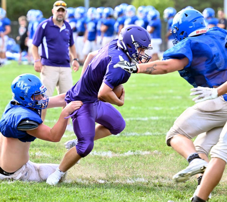 Martha's Vineyard running back Christian Turner drags a UCT defender during a scrimmage Tuesday in Mashpee.