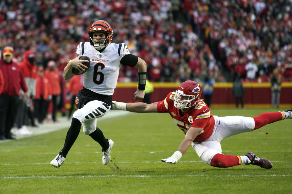 Cincinnati Bengals quarterback Jake Browning (6) runs past Kansas City Chiefs defensive end George Karlaftis (56) during the first half of an NFL football game Sunday, Dec. 31, 2023, in Kansas City, Mo. (AP Photo/Ed Zurga)