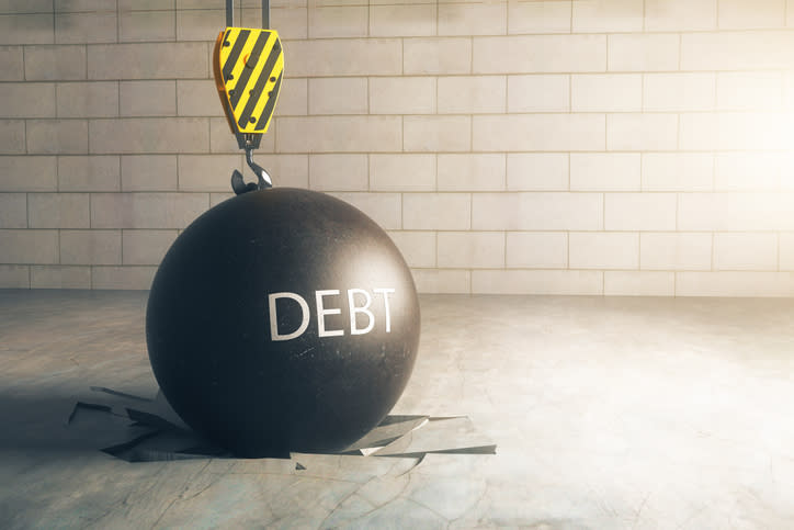 A wrecking ball with the word DEBT on it.