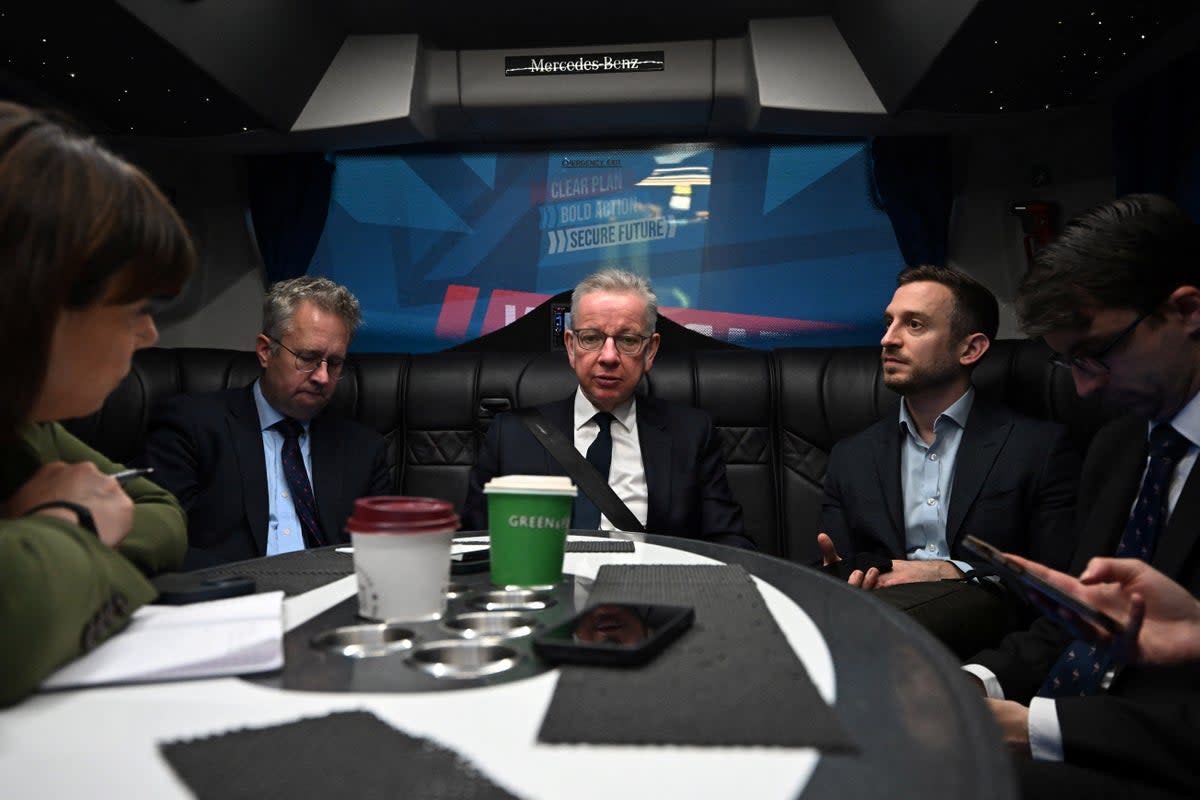 Michael Gove at the back of the battle bus as journalists ready their questions  (Reuters)