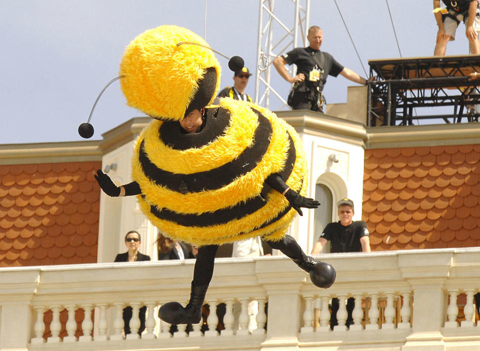 jerry hanging off the side of the building in a large bee suit