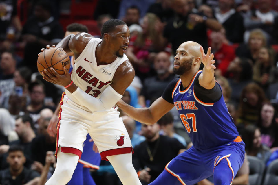 Miami Heat center Bam Adebayo (13) looks for an open teammate past New York Knicks forward Taj Gibson (67) during the first half of an NBA basketball game Friday, Dec. 20, 2019, in Miami. (AP Photo/Wilfredo Lee)