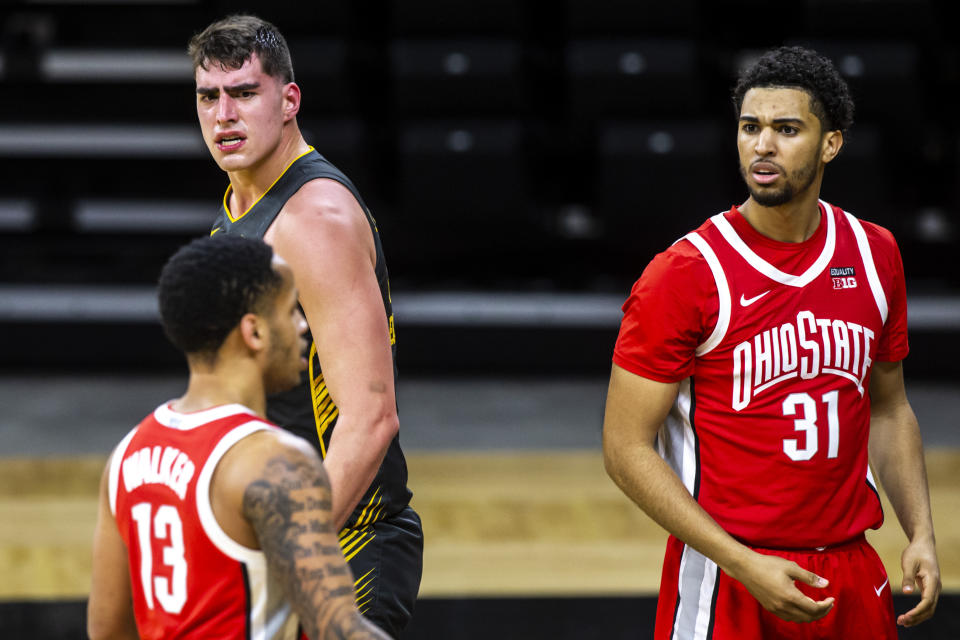 Iowa center Luka Garza, top left, reacts after drawing a foul in the first half of an NCAA college basketball game as Ohio State forward Seth Towns (31) looks on Thursday, Feb. 4, 2021, in Iowa City, Iowa. (Joseph Cress/Iowa City Press-Citizen via AP)