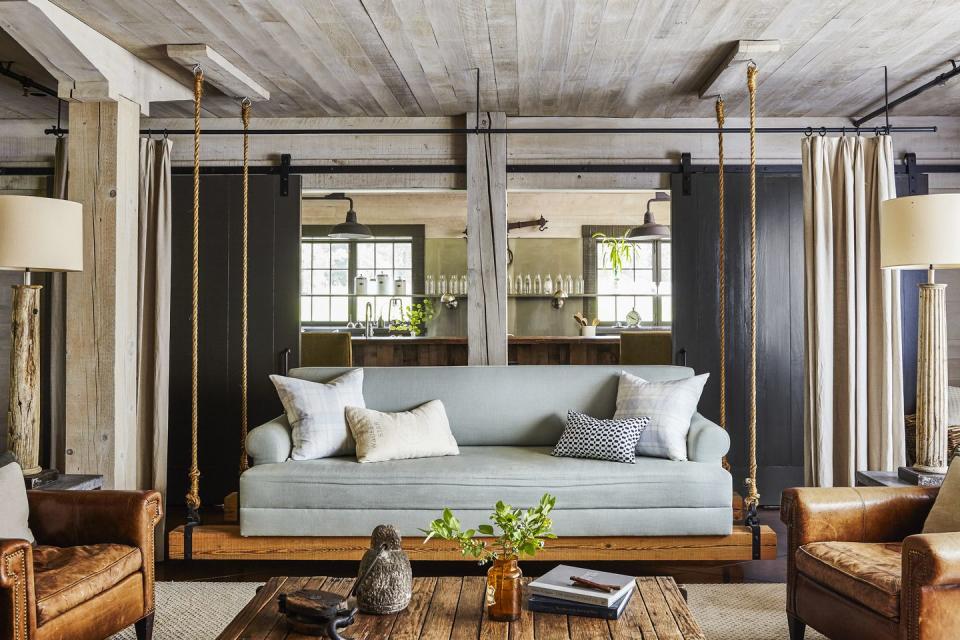 living room with an upholstered sofa swing and sliding barn doors behind