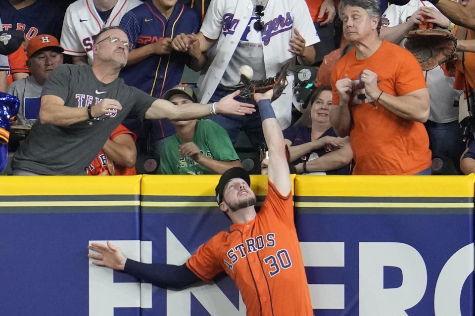 Houston Astros' Kyle Tucker tries to catch a two run home run hit by Texas Rangers' Jonah Heim during the fourth inning of Game 6 of the baseball AL Championship Series Sunday, Oct. 22, 2023, in Houston. (AP Photo/Godofredo A. Vásquez)