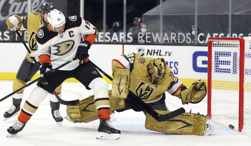 Vegas Golden Knights goalie Marc-Andre Fleury blocks a shot as Anaheim Ducks center Ryan Getzlaf (15) looks for a rebound during the first period of an NHL hockey game Saturday, Jan. 16, 2021, in Las Vegas. (AP Photo/Isaac Brekken)