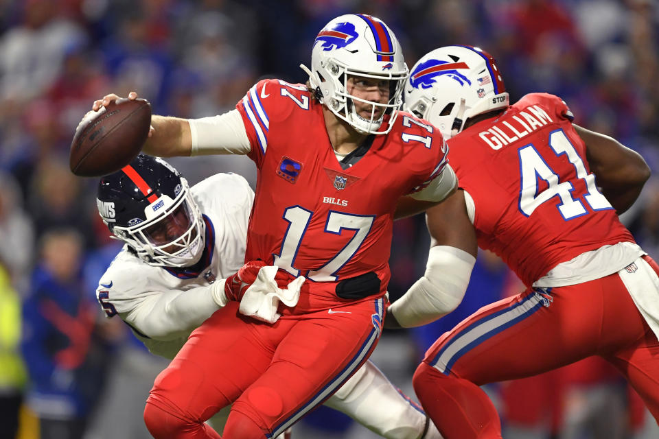 Buffalo Bills quarterback Josh Allen (17) tries to break free from New York Giants linebacker Kayvon Thibodeaux, left, during the second half of an NFL football game in Orchard Park, N.Y., Sunday, Oct. 15, 2023. (AP Photo/Adrian Kraus)