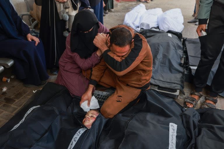 Palestinos lloran junto a los cuerpos de familiares que murieron en ataques aéreos israelíes durante la noche en el campamento de refugiados de Rafah, en el sur de la Franja de Gaza, en el hospital Najjar de Rafah el 27 de febrero de 2024.