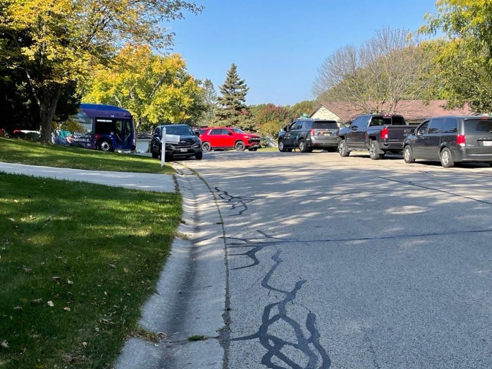 Police vehicles gather outside a Hartland apartment complex Friday, Oct. 21, 2022 following a fatal fire that left six people dead. Police said a criminal investigation is underway.