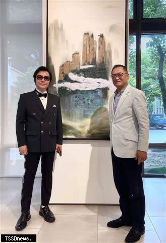 藝術家陳歡（左）在他的油畫作品「山在虛無縹緲間」前與景薰樓拍賣公司創辦人林振廷（右）合影留念。