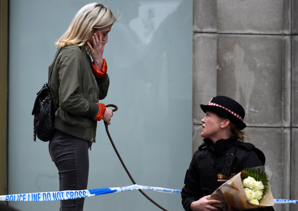 A woman walking her dog reacts near London Bridge while talking to a police officer.&nbsp;