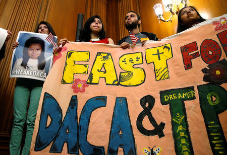 DACA recipients hold up a sign after an event by Democrats calling for Congressional Republicans to bring forward immigration legislation on Capitol Hill in Washington, U.S., September 6, 2017. REUTERS/Joshua Roberts