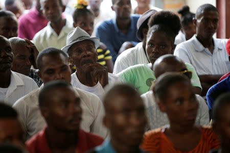 Haitians watch a broadcast of outgoing United Nations Secretary-General Ban Ki-moon's apology to the people of Haiti for the world body's role in a deadly cholera outbreak, on a screen at the Office of International Lawyers in Port-au-Prince, Haiti, December 1, 2016. REUTERS/Andres Martinez Casares