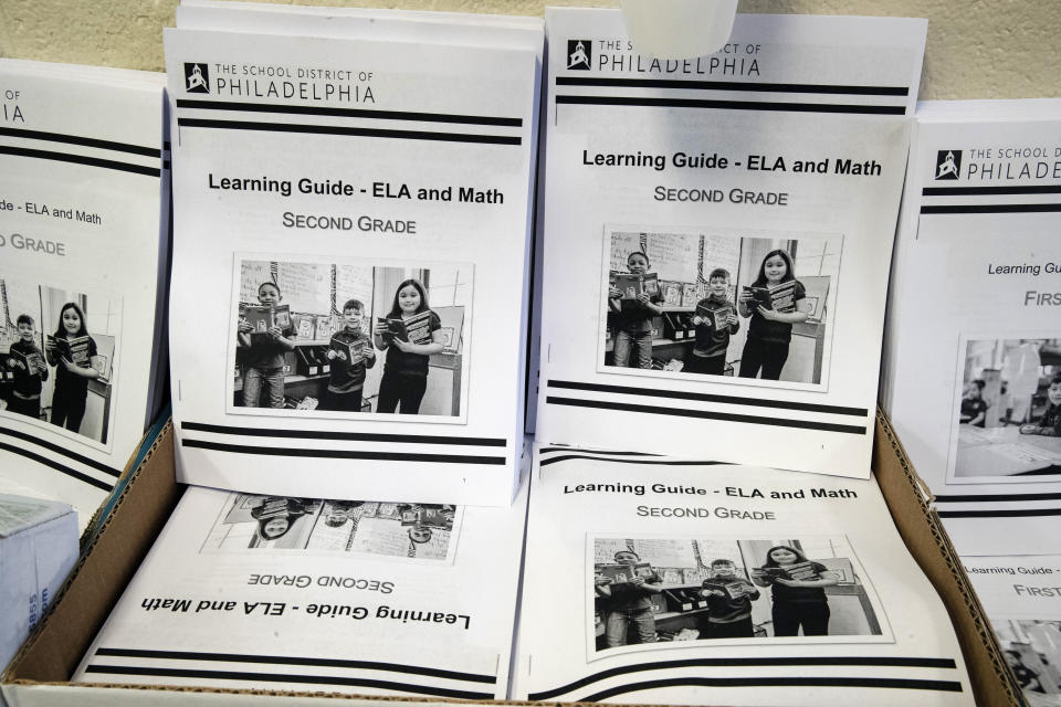 In this Wednesday, March 25, 2019, photo are learning guides to be distributed to students at John H. Webster Elementary School in Philadelphia. Only about half of the district’s high school students have a laptop or tablet and home internet service. As schools now appear likely to be closed due to the coronavirus for longer than anticipated, the district plans to buy 50,000 Chromebooks and begin online instruction by mid-April. (AP Photo/Matt Rourke)