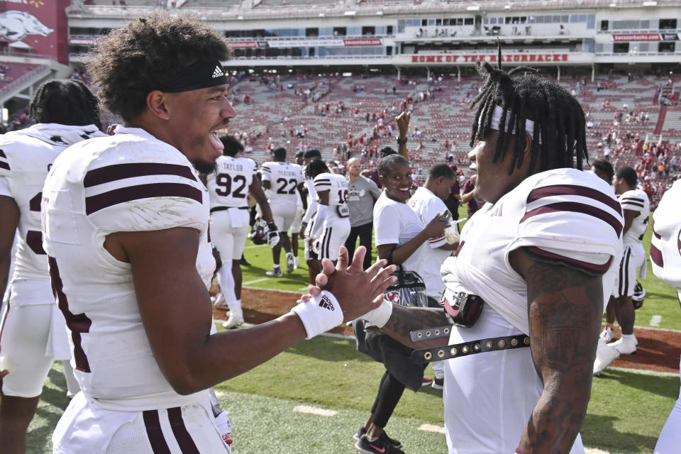 Mississippi State quarterback Mike Wright, left, celebrates with Zavion Thomas, right, after defeating Arkansas in an NCAA college football game Saturday, Oct. 21, 2023, in Fayetteville, Ark. (AP Photo/Michael Woods)