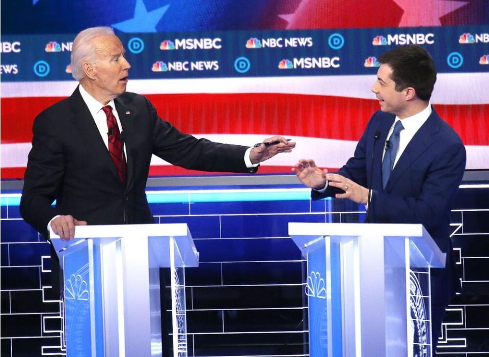 From left to right: Joe Biden and Pete Buttigieg share a brief laugh during a mixup in Biden's answer about transparency. | Mario Tama/Getty