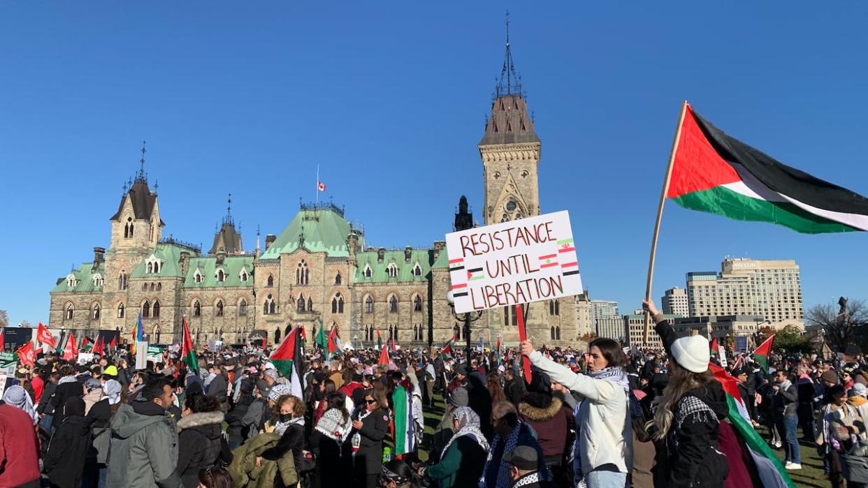 A large crowd gathers for a pro-Palestinian rally on Parliament Hill in Ottawa on Saturday. Political leaders are condemning the presence of a sign bearing a swastika at the rally. (Rebecca Kwan/Radio-Canada - image credit)