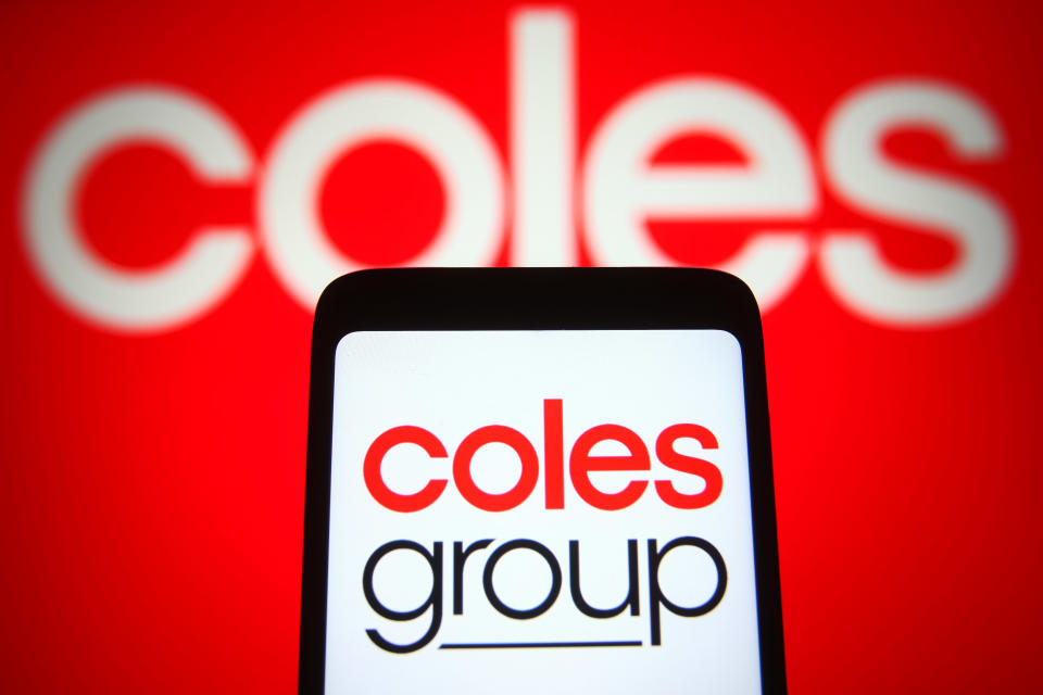 Coles Group Limited logo is seen displayed on a smartphone and PC screen.