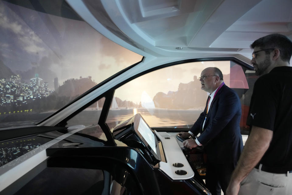 Norbert Brosi drives a boat on the Future Helm boat simulator at the Brunswick booth during the CES tech show Friday, Jan. 6, 2023, in Las Vegas. The technology was on display at the booth to allow convention goers to experience auto boat docking and other technologies both in use and in development. (AP Photo/John Locher)