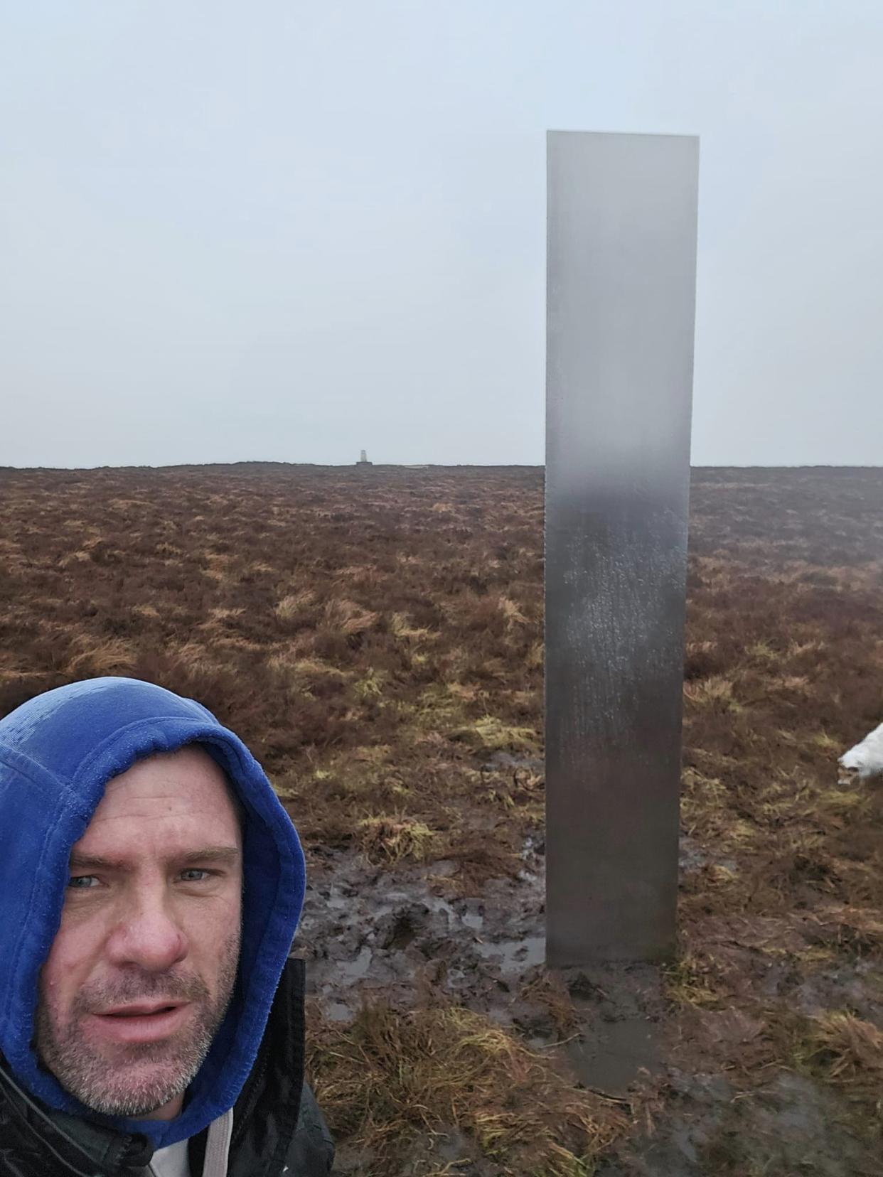 Man standing next to monolith 