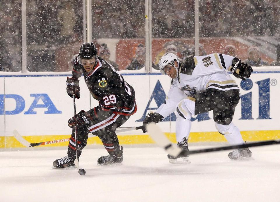 Chicago Blackhawks left wing Bryan Bickell (29) handles the puck away from Pittsburgh Penguins left wing James Neal (18) during the first period of an NHL Stadium Series hockey game at Soldier Field on Saturday, March 1, 2014, in Chicago. (AP Photo/Charles Rex Arbogast)