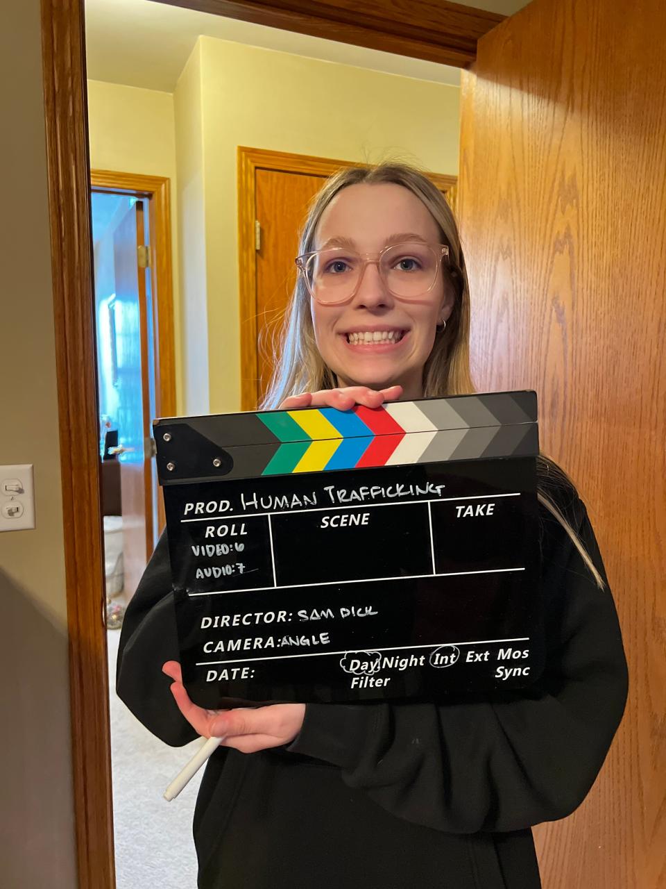 Aubrey Poster, junior at Oshkosh North High School and associate producer of the student film "A Deal with Romeo," holds up the movie clapperboard during filming.