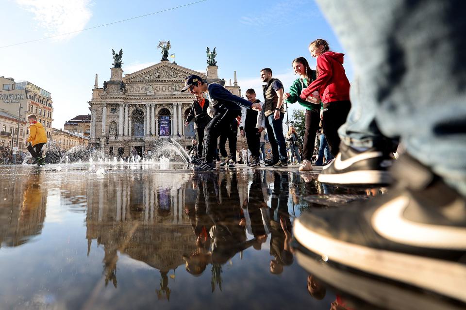 Children and adults play in a fountain in a square of Lviv Oblast in western Ukraine on Friday, May 5, 2023. | Scott G Winterton, Deseret News