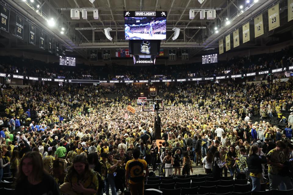 Wake Forest fans storm the court at Lawrence Joe Veterans Memorial Coliseum after an upset of Duke on Saturday. Blue Devils star Kyle Filipowski was injured after colliding with a fan, causing several coaches and commentators to call for an end to court storming.