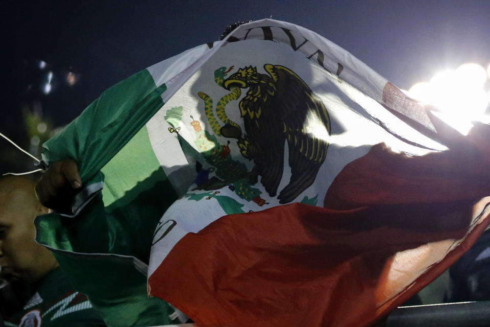 A fan holds a Mexico flag during the second half of a CONCACAF Gold Cup soccer match between Mexico and Cuba in Pasadena, Calif., Saturday, June 15, 2019. Mexico won 7-0. (AP Photo/Ringo H.W. Chiu)