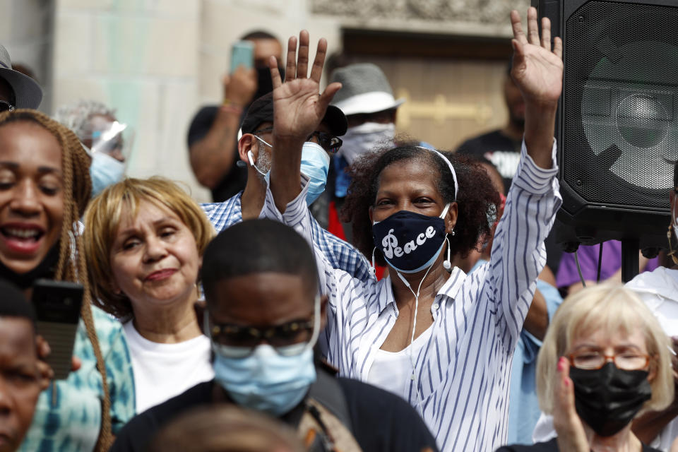 Parishioners of St. Sabina Catholic Church cheers as Father Michael Pfleger speaks for first time during a press conference after his reinstatement by Archdiocese of Chicago, Monday, May 24, 2021, in front of St. Sabina Catholic Church in the Auburn Gresham neighborhood in Chicago. (AP Photo/Shafkat Anowar)