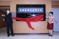 Katharine Chang, right, chairperson of Straits Exchange Foundation, and Chen Ming-tong, minister of the Mainland Affairs Council, unveil the plaque of the Taiwan Hong Kong Service Exchange Office during an opening ceremony in Taipei, Taiwan, Wednesday, July 1, 2020. Taiwan officially opened the specialized office to support Hong Kong people seeking to move to Taiwan after China’s passage of a national security law for Hong Kong. (AP Photo /Chiang Ying-ying)