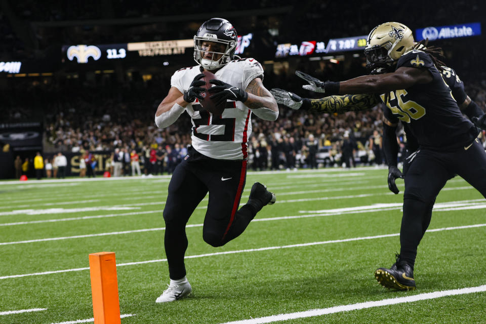 Atlanta Falcons running back Tyler Allgeier (25) runs in for a two-point conversion in front of New Orleans Saints linebacker Demario Davis (56) in the second half of an NFL football game in New Orleans, Sunday, Dec. 18, 2022. (AP Photo/Butch Dill)