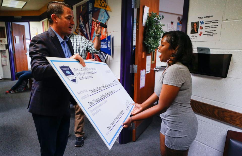 Male High School senior Tamiya King reacts while she receives a $10,500 scholarship check to UofL from JCPS Superintendent Marty Pollio Friday morning. King wants to become an attorney. May 19, 2023.