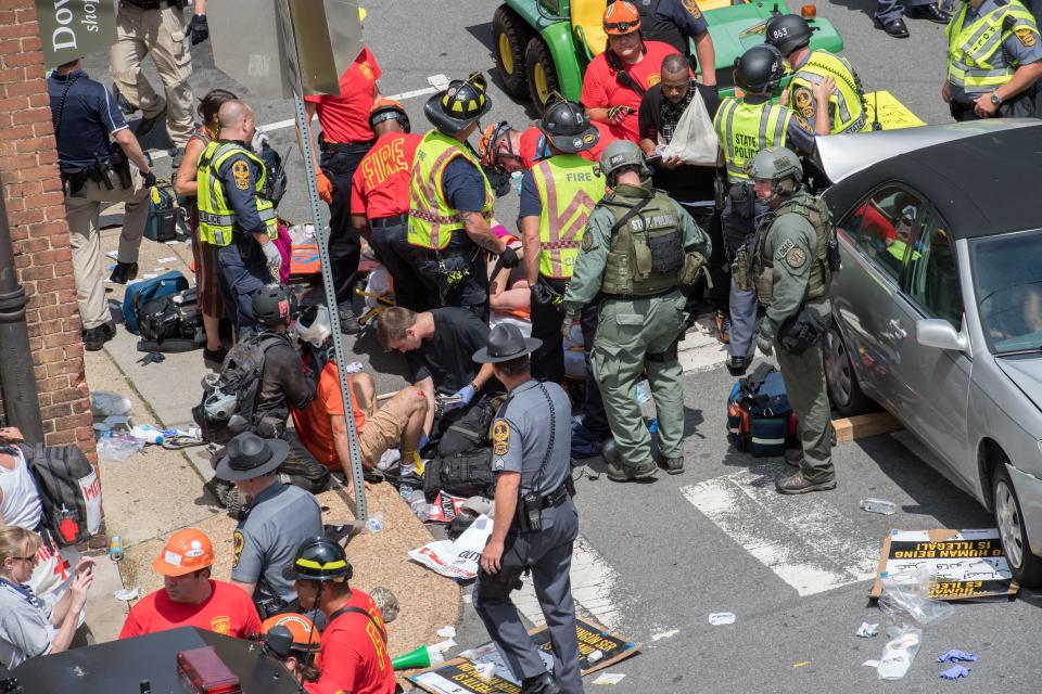 People receive first aid after a car drove&nbsp;into a crowd of protesters in Charlottesville, Virginia. (Photo: PAUL J. RICHARDS via Getty Images)