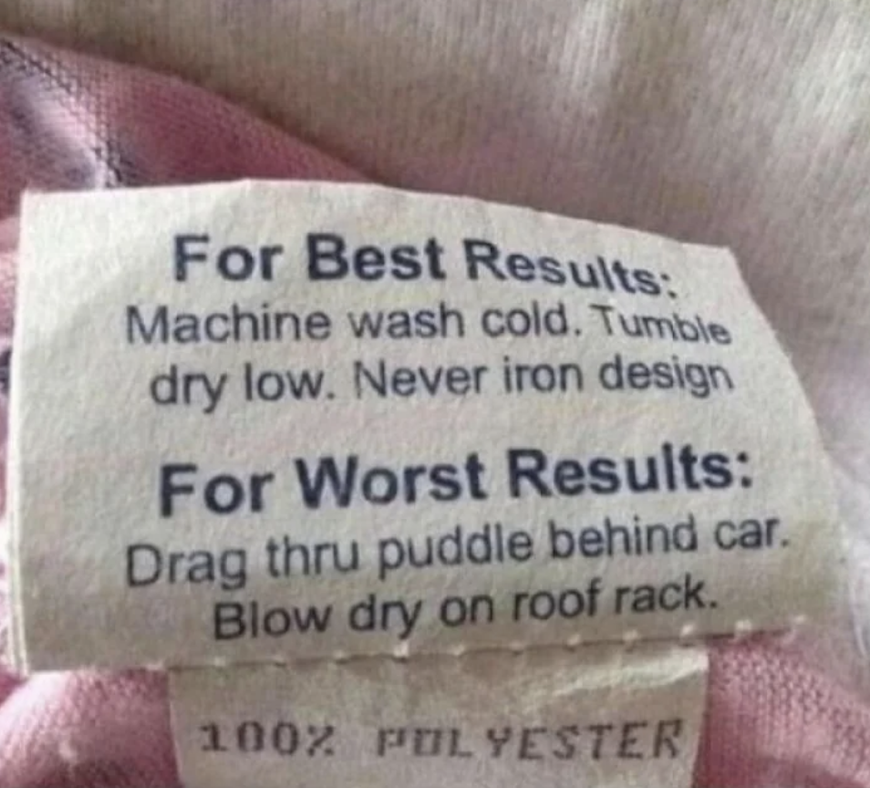 Laundry care label with humorous instructions: "For Best Results: Machine wash cold. Tumble dry low. Never iron design. For Worst Results: Drag thru puddle behind car. Blow dry on roof rack." 100% polyester