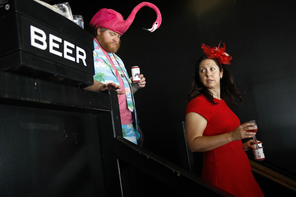 Spectators walk past a case of beer at Pimlico Race Course, Saturday, May 18, 2019, ahead of the Preakness Stakes horse race in Baltimore. (AP Photo/Patrick Semansky)