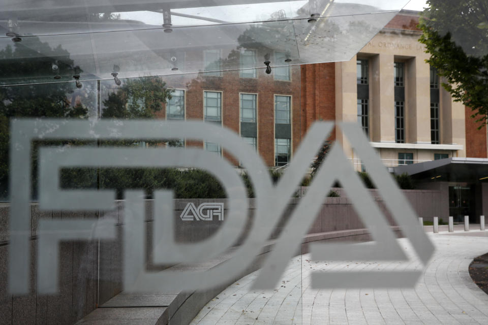 FILE - This Aug. 2, 2018, file photo shows the U.S. Food and Drug Administration building behind FDA logos at a bus stop on the agency's campus in Silver Spring, Md. Teen vapers prefer Juul and mint is the #1 flavor among many of them, suggesting a shift after the company’s fruit and dessert flavors were removed from retail stores, new U.S. research suggests. The results are in a pair of studies published Tuesday, Nov. 5, 2019, including a report from the Food and Drug Administration and federal Centers for Disease Control and Prevention indicating that the U.S. teen vaping epidemic shows no signs of slowing down. (AP Photo/Jacquelyn Martin, File)