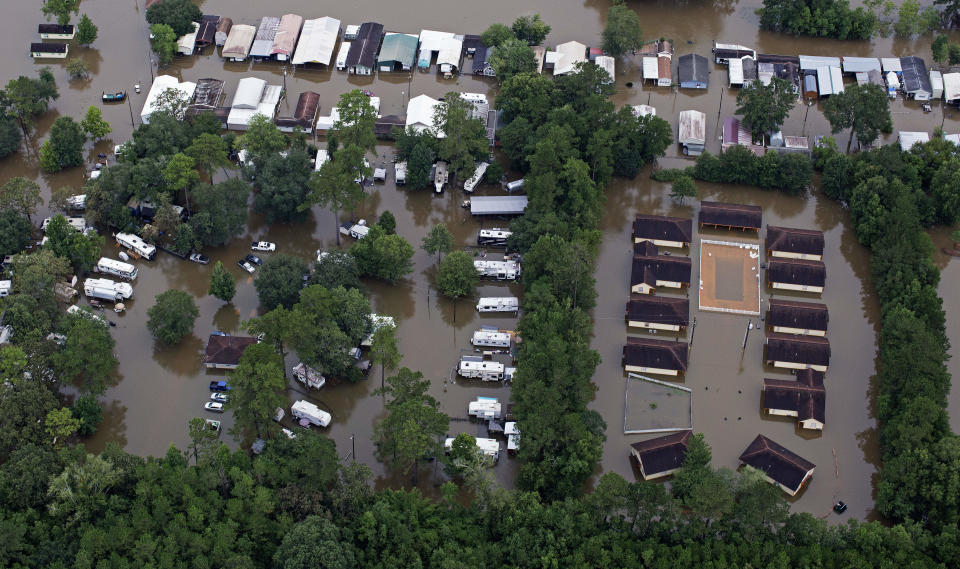 FILE- In this Aug. 13, 2016 aerial photo over Amite, La., flooded homes are seen from heavy rains inundating the region. Memories of an epic flood that caused billions of dollars in damage had Louisiana's capital on edge Friday, July 12, 2019, as Barry gained strength in the Gulf of Mexico. (AP Photo/Max Becherer, File)