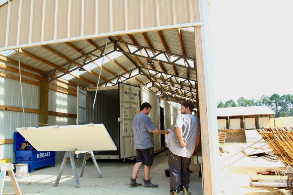Bloxx Building employees Kristopher Auderer, left, and Casey Jones work on a project at the company’s manufacturing facility in Saucier, where shipping containers are sold, or converted for housing or offices.