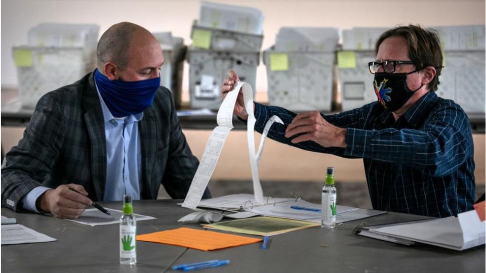 Election officials looking at absentee ballots