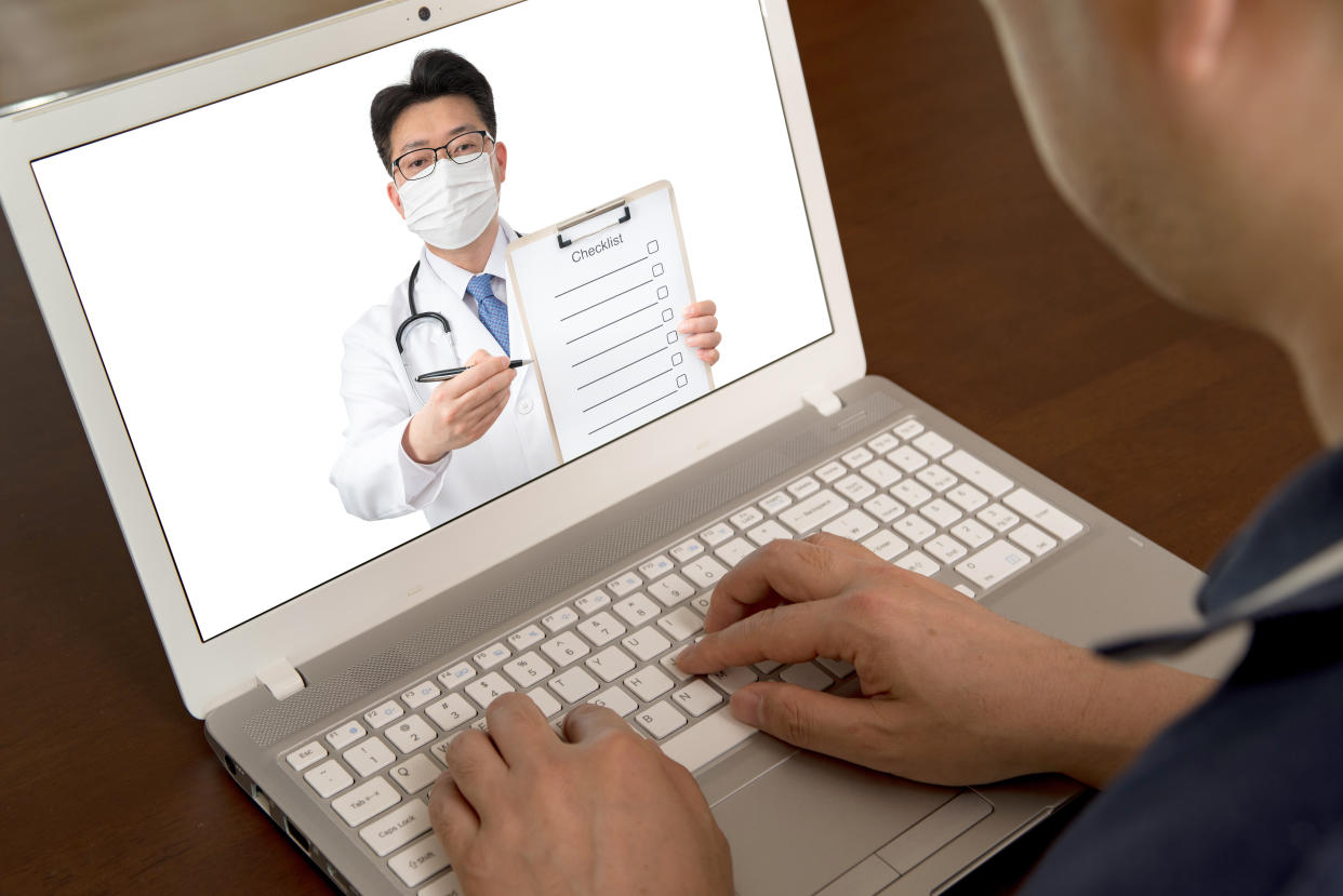 an Asian doctor who is remotely consulting with a patient. Telehealth concept.  The person on the screen is the same person.