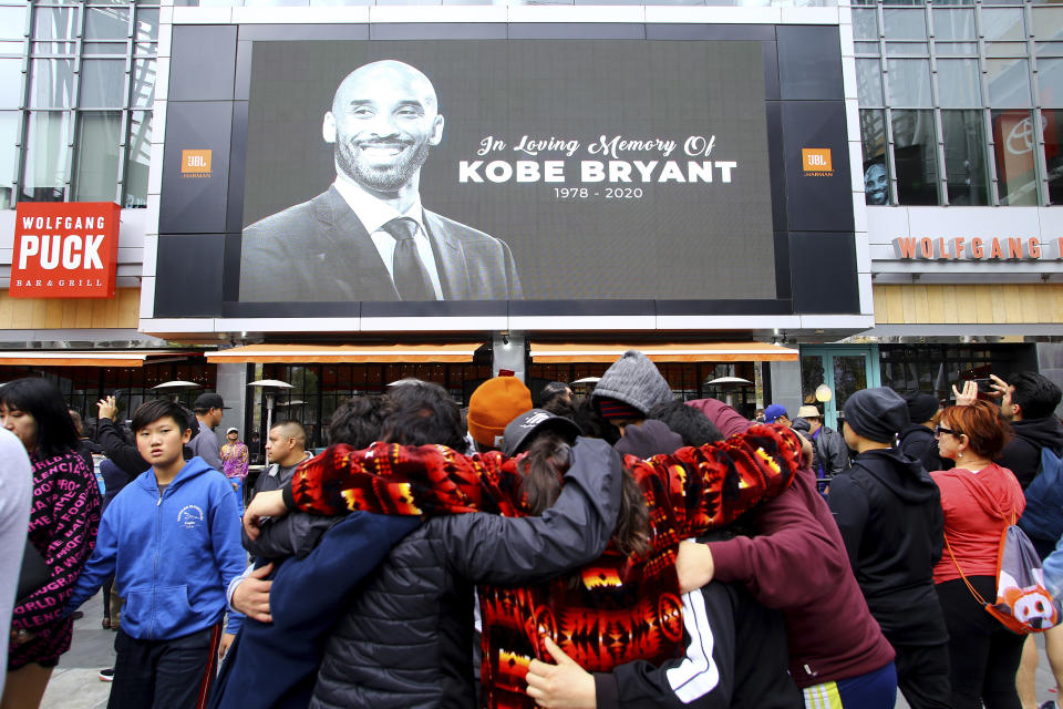 Fans of Kobe Bryant mourn in front of his image at the LALive area across from Staples Center, home of the Los Angeles Lakers, after word of the Lakers star's death in a helicopter crash, in downtown Los Angeles Sunday, Jan. 26, 2020. (AP Photo/Matt Hartman)