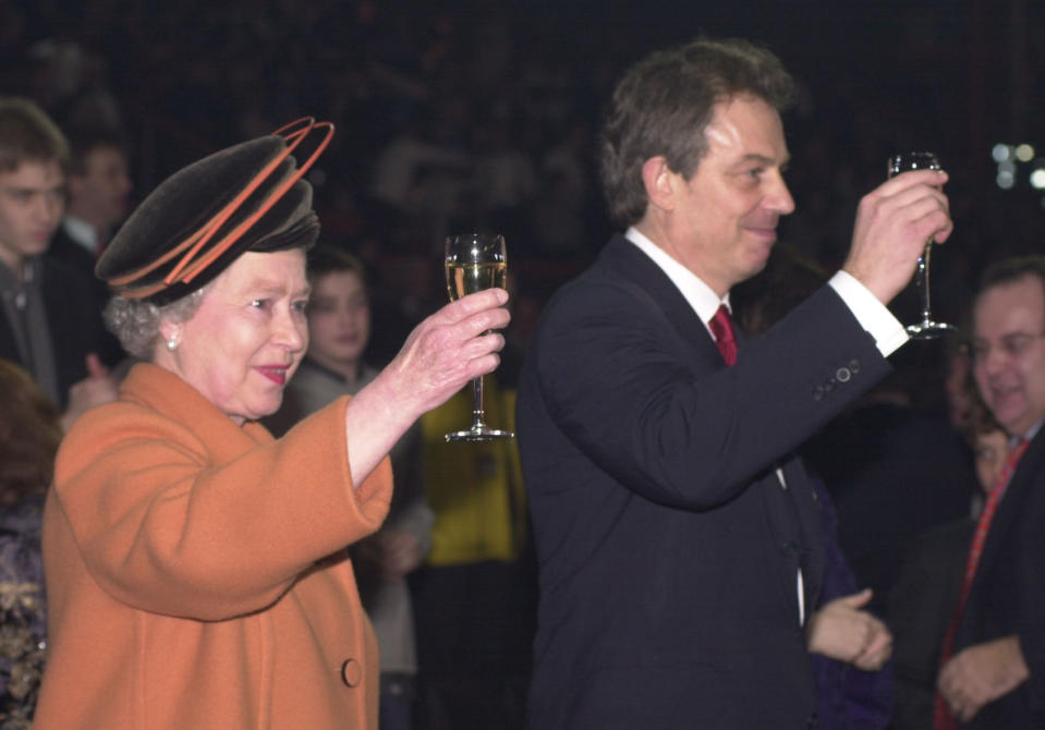 <p>Queen Elizabeth II and Prime Minister Tony Blair raise their glasses as midnight strikes during the Opening Celebrations at the Millennium Dome in Greenwich, London. (PA) </p>